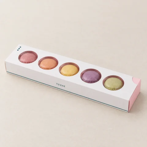 AI design concept: closed white macaron sleeve with five round windows, pink tray and teal TUZHE print