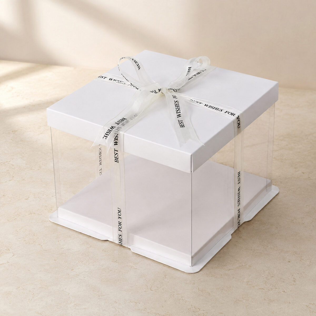Low empty clear cake box with a white square lid, white base and ivory printed ribbon