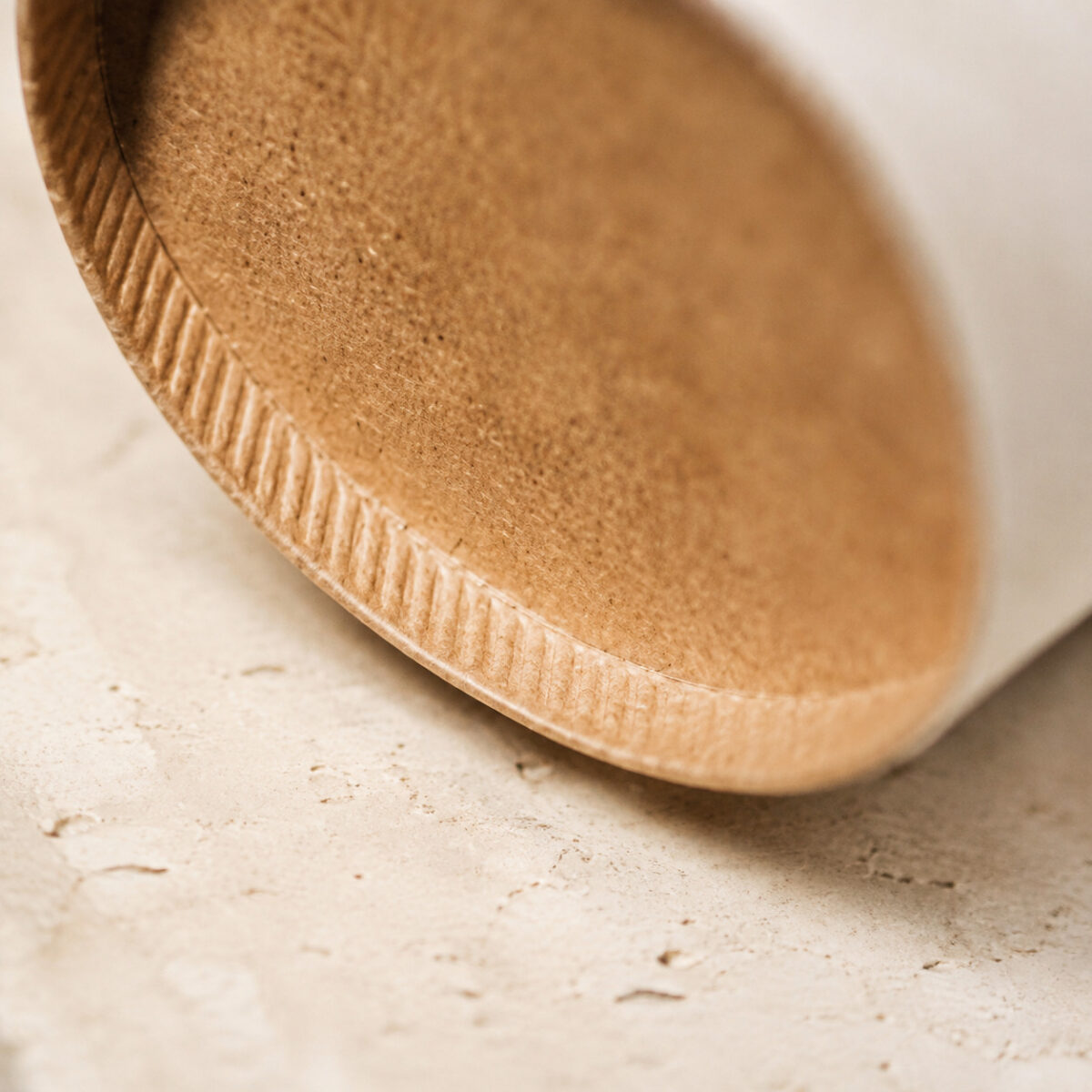 Close-up of the recessed base and crimped edge of a kraft paper cup