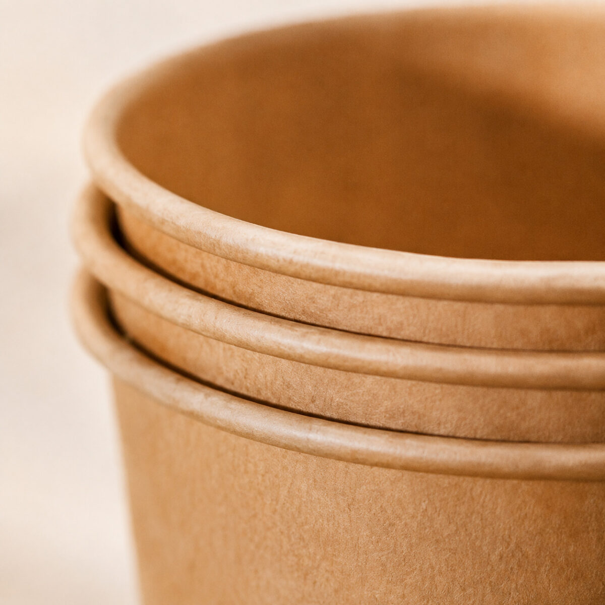 Close-up of three rolled rims on nested kraft paper cups