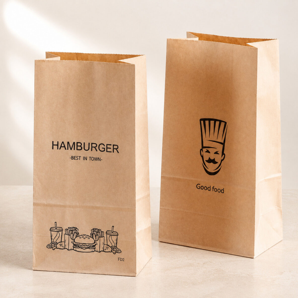 Two printed kraft takeaway bags with serrated openings and folded side gussets