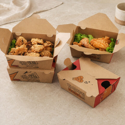 Four printed kraft chicken cartons with open food-filled boxes and a closed four-flap box in front
