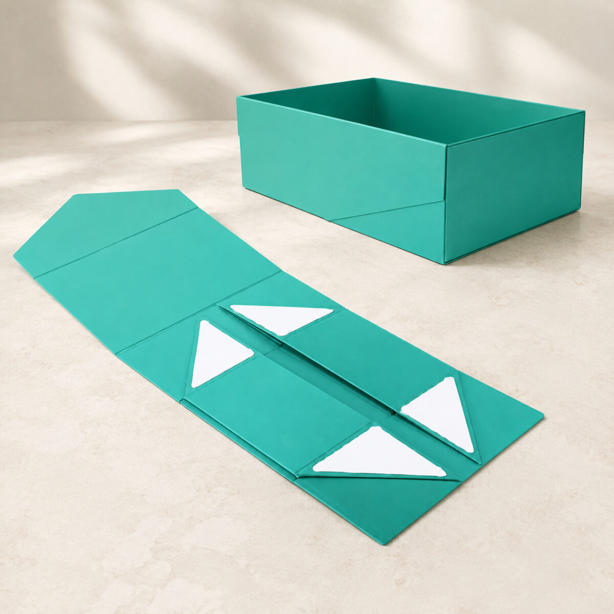 Turquoise gift box shown assembled and folded flat with four triangular adhesive liners
