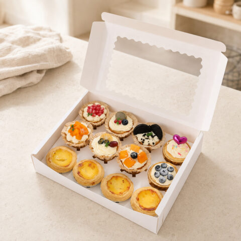 Open white window bakery box with an insert holding four egg tarts and eight decorated cupcakes