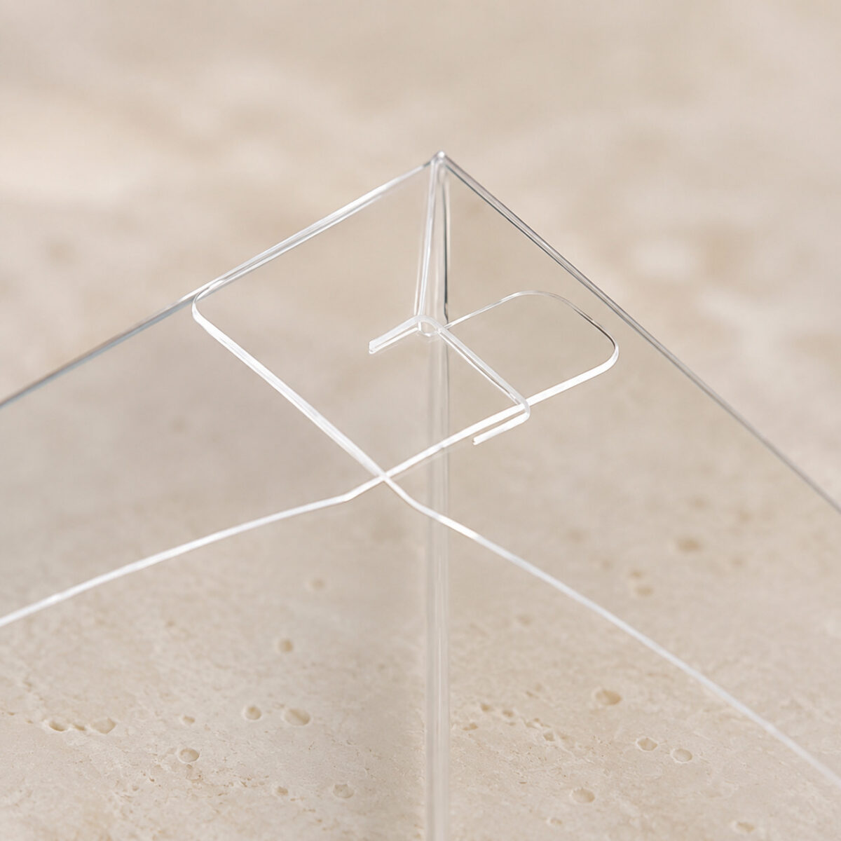Close-up of overlapping clear cake box flaps and a folded corner tab