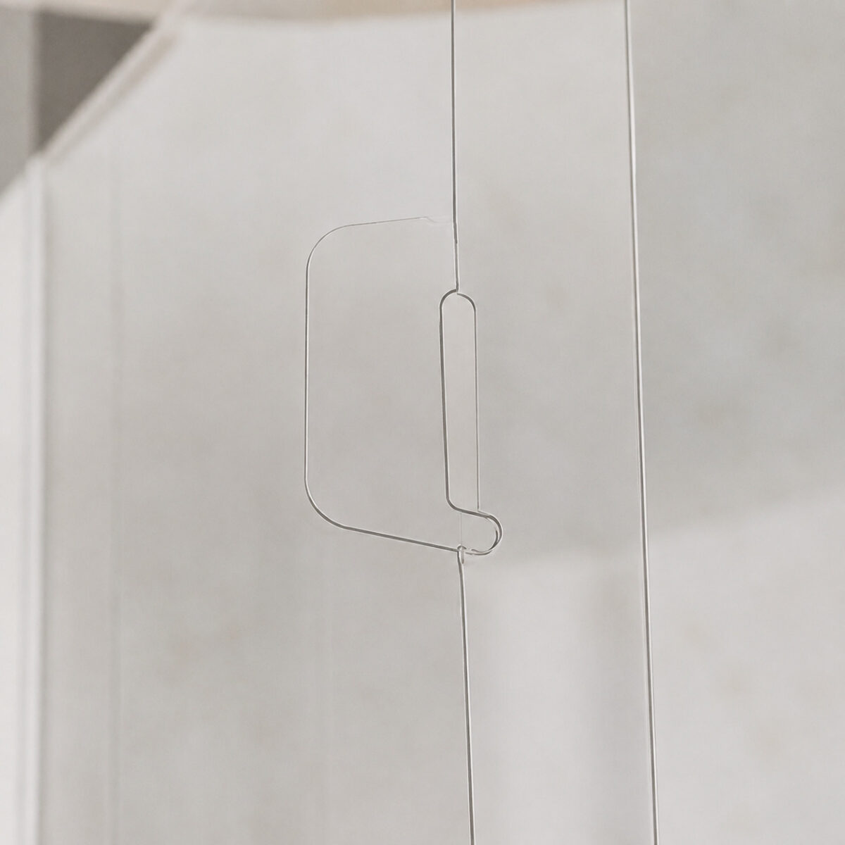 Close-up of a sheet-panel seam with an elongated rounded tab and a curved locking tip